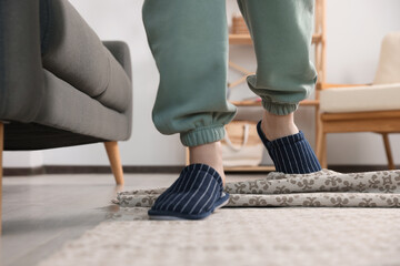 Man tripping over rug at home, closeup