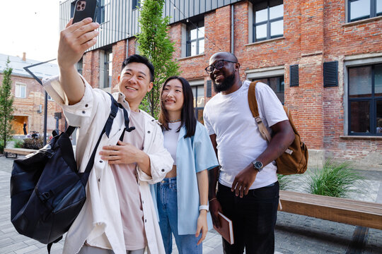 Multiracial friends taking selfie on phone 