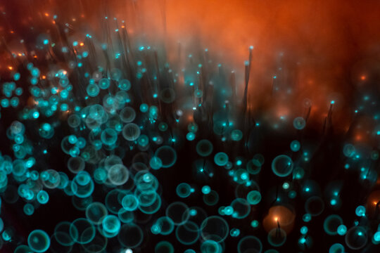 Glowing fibre optics with bright turquoise blue circular bokeh