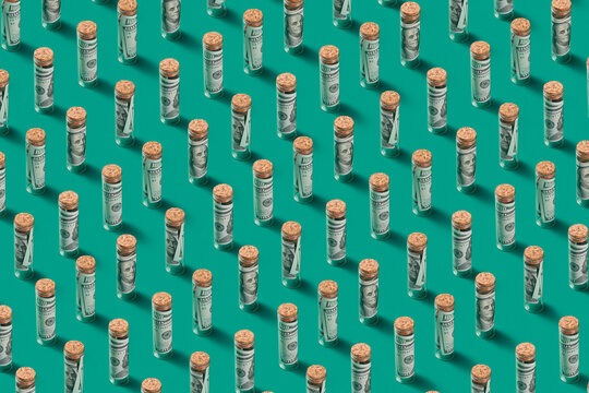Pattern of 100 dollar banknotes in glass vials.