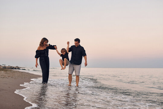 family playing along the shoreline