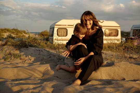 mommy with a son sitting on a sand