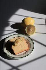 Homemade Lemon cake decorated on white background under sunlight. Tasty dessert for winter holidays. Light and shadow.