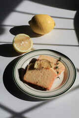 Homemade Lemon cake decorated on white background under sunlight. Tasty dessert for winter holidays. Light and shadow.