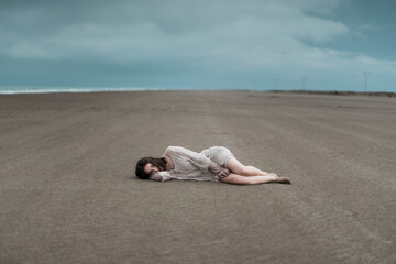 Obraz premium Woman lying on wide empty beach