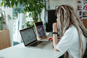 Faceless female using laptop.