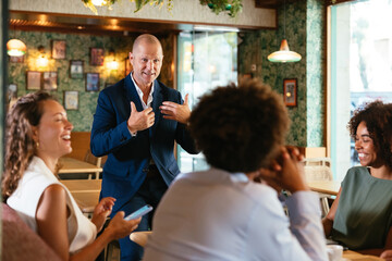 Businessman speaking to colleagues in restaurant