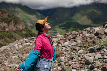 A traveler girl enjoys the sun in the beautiful mountains