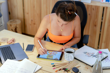 Female illustrator drawing on tablet at desk 