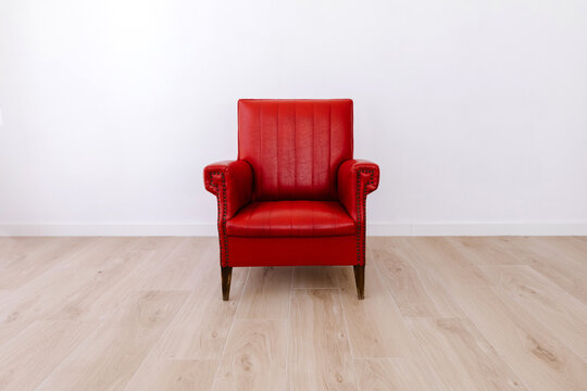 Red armchair against white wall
