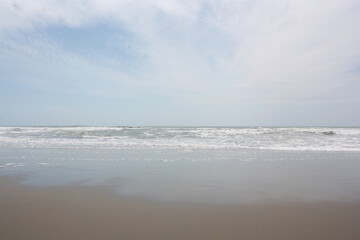 Fototapeta na wymiar Sky reflecting in wet sand, Pacific beach