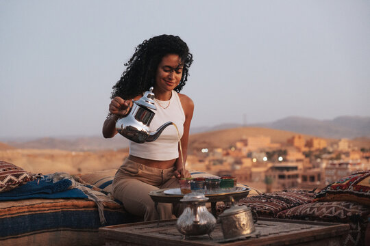 Moroccan girl drinking tea in a terrace