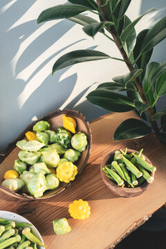 Fresh Organic Okra and Patisson Squash on a wooden rustic table