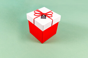Red gift box and white lid with red ribbon bow on a light green background, Merry Christmas and Happy New Year present, Holiday gift surprise,Decorative festival