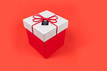Red gift box and white lid with red ribbon bow on a red background, Merry Christmas and Happy New Year present, Holiday gift surprise,Decorative festival.