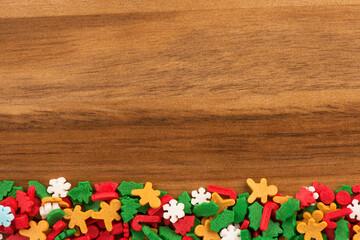 Christmas candies for pastry decoration on a wooden plank. Directly above. Copy space for your text.