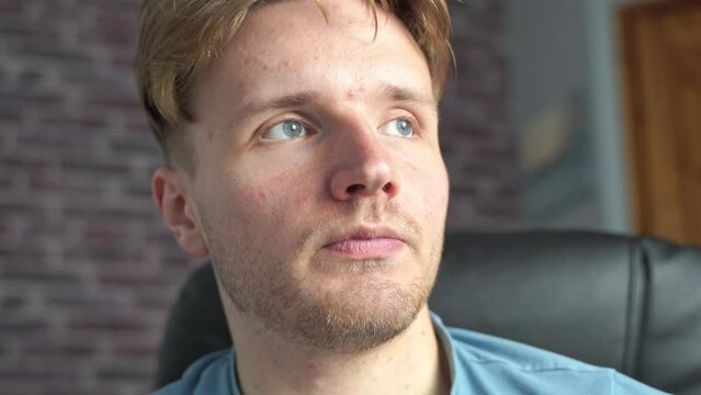 A young man with blue eyes is in deep thought.  He thinks about his next move with regard to his personal life and career