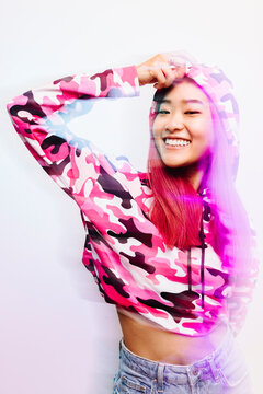 Cheerful chinese woman with colorful jacket looking at camera