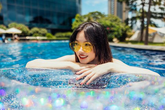Happy girl with sparkling ring at pool