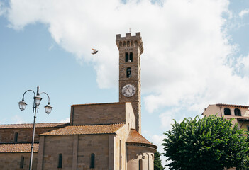 Bird flying past Fiesole Cathedral and bell tower in Italy