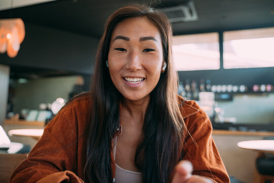 Asian woman smiling in the middle of talking to you