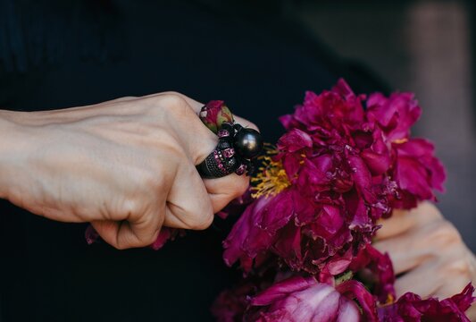 Anonymous woman ripping petals of bright flower - agression - emotion