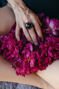 Hand with beautiful ring touching flowers
