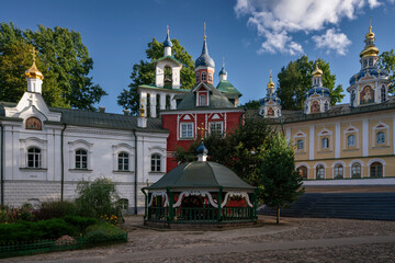 Fototapeta na wymiar Sretensky Church, Assumption Cathedral, the Great Bell Tower, the sacristy and the holy well of the Holy Dormition Pskov-Pechersk Monastery on a sunny summer day, Pechory, Pskov region, Russia