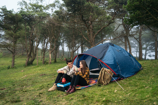 Couple camping in the forest using camping gas