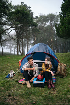 Couple camping in the forest using camping gas