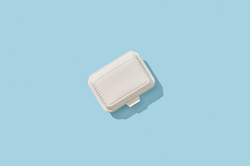 White plastic lunch box on blue background.