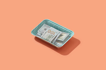 Dollar bills in open blue lunch box.
