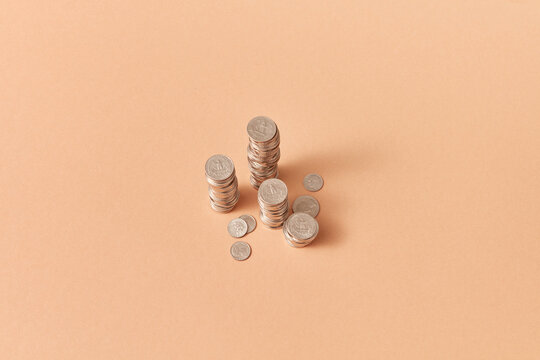 Stacks of coins on coral background.