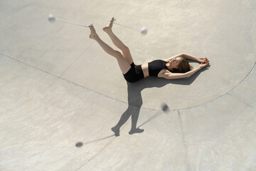 Sportive girl is training with poi balls in skatepark