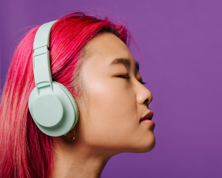 Chinese woman in headphones with closed eyes