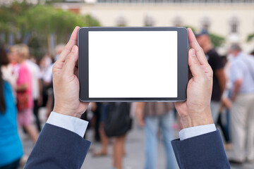 Hand holding mobile tablet with crowd on background