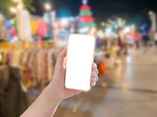 Hand holding mobile phone with shopping mall background