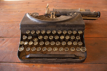 Antigua máquina de escribir mecanografía marca Junior con botones en español - obrazy, fototapety, plakaty