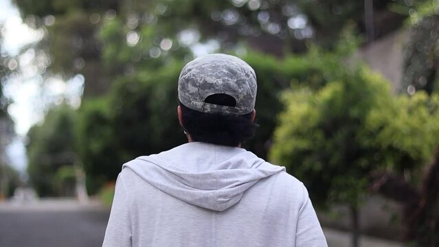 Joven chico caminando en la calle durante el d&iacute;a