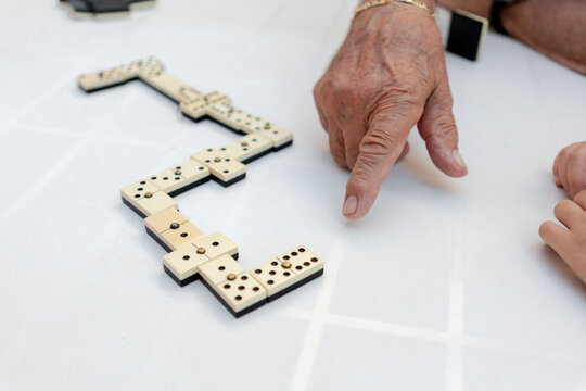 Old man playing dominoes in a residence