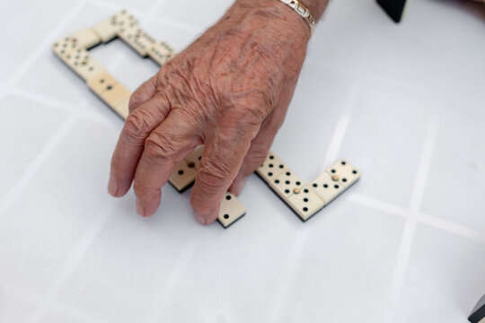Old man playing dominoes in a residence