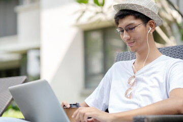 Young man using laptop computer outdoor.