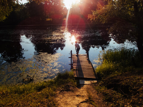 A boy is playing on the lake, sunset.