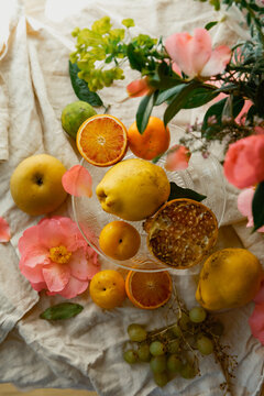different whole and broken fruits are lying on a linen tablecloth