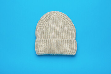 Light knitted hat on a blue background.