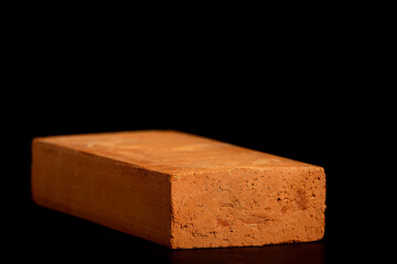 Solid clay bricks used in construction are laid on a black background.
