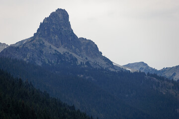 Fototapeta na wymiar A mountain peak under a hazy grayish-white sky in Okanogan Wenatchee National Forest, Washington.