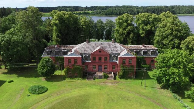 Old red brick manor in Katvari, Latvia, aerial approaching view