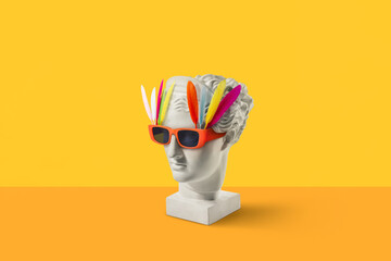 Gypsum Diana head in sunglasses with feathers.