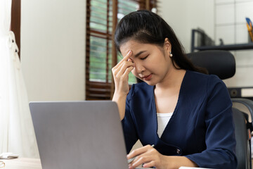 Depressed businesswoman, Portrait of a young tired businesswoman using laptop and working on some reports from home.